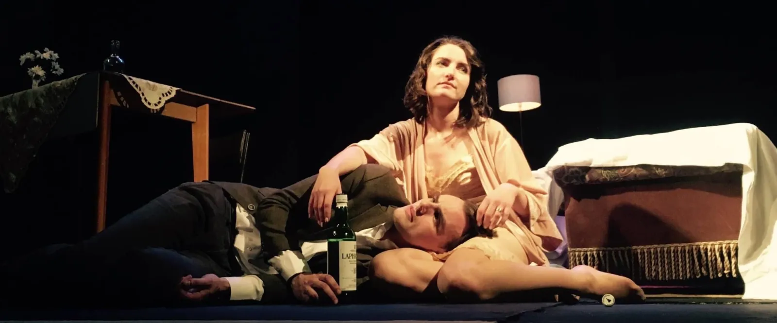 Danny Solomon on stage — lying on the floor with a co-star, whisky bottle