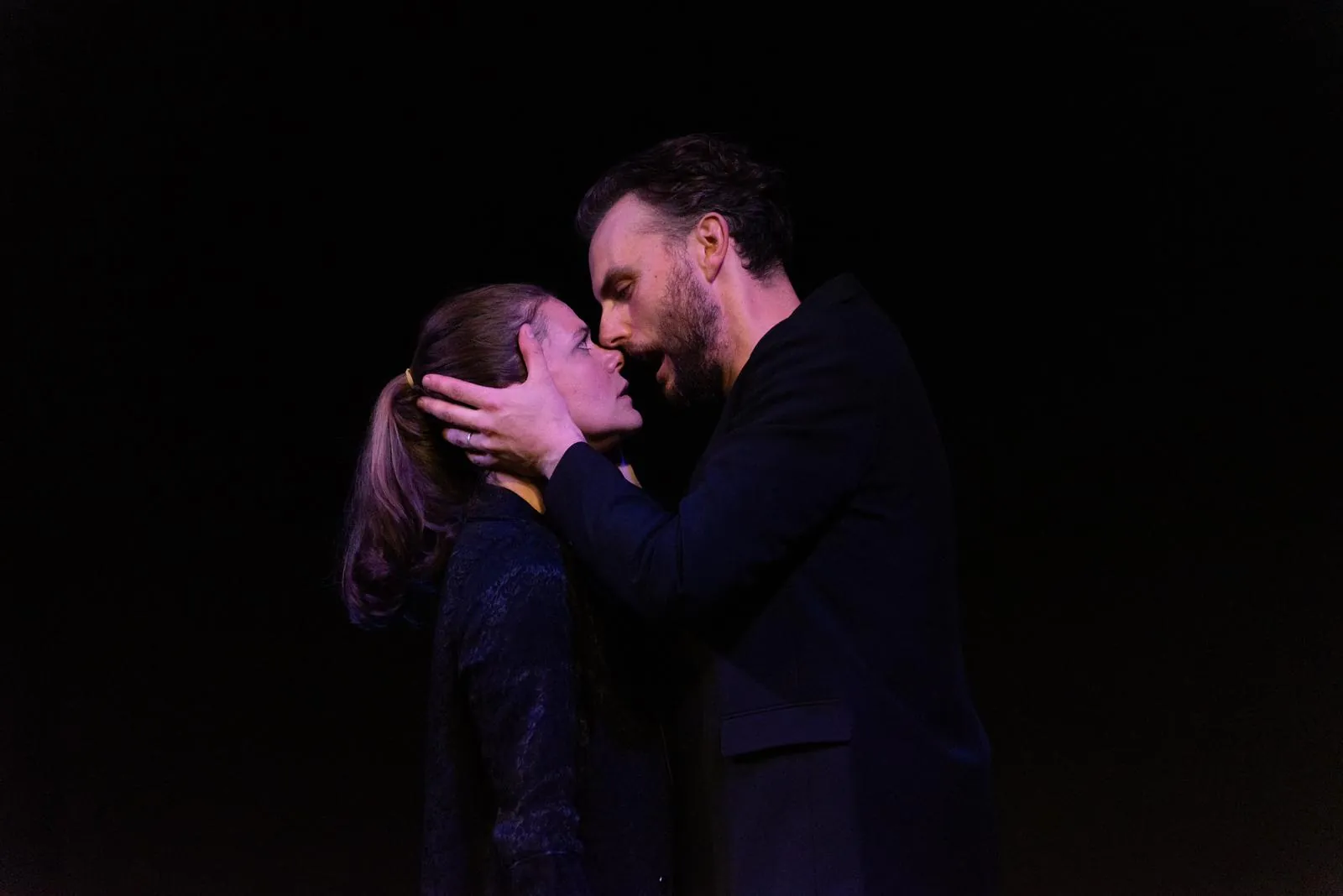 Danny Solomon on stage — close embrace, profile, purple light
