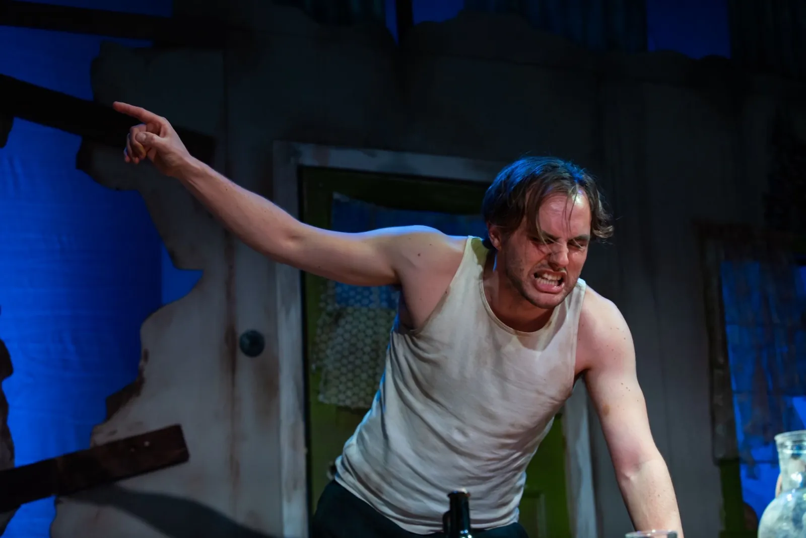 Danny Solomon on stage — sleeveless top, pointing, angry