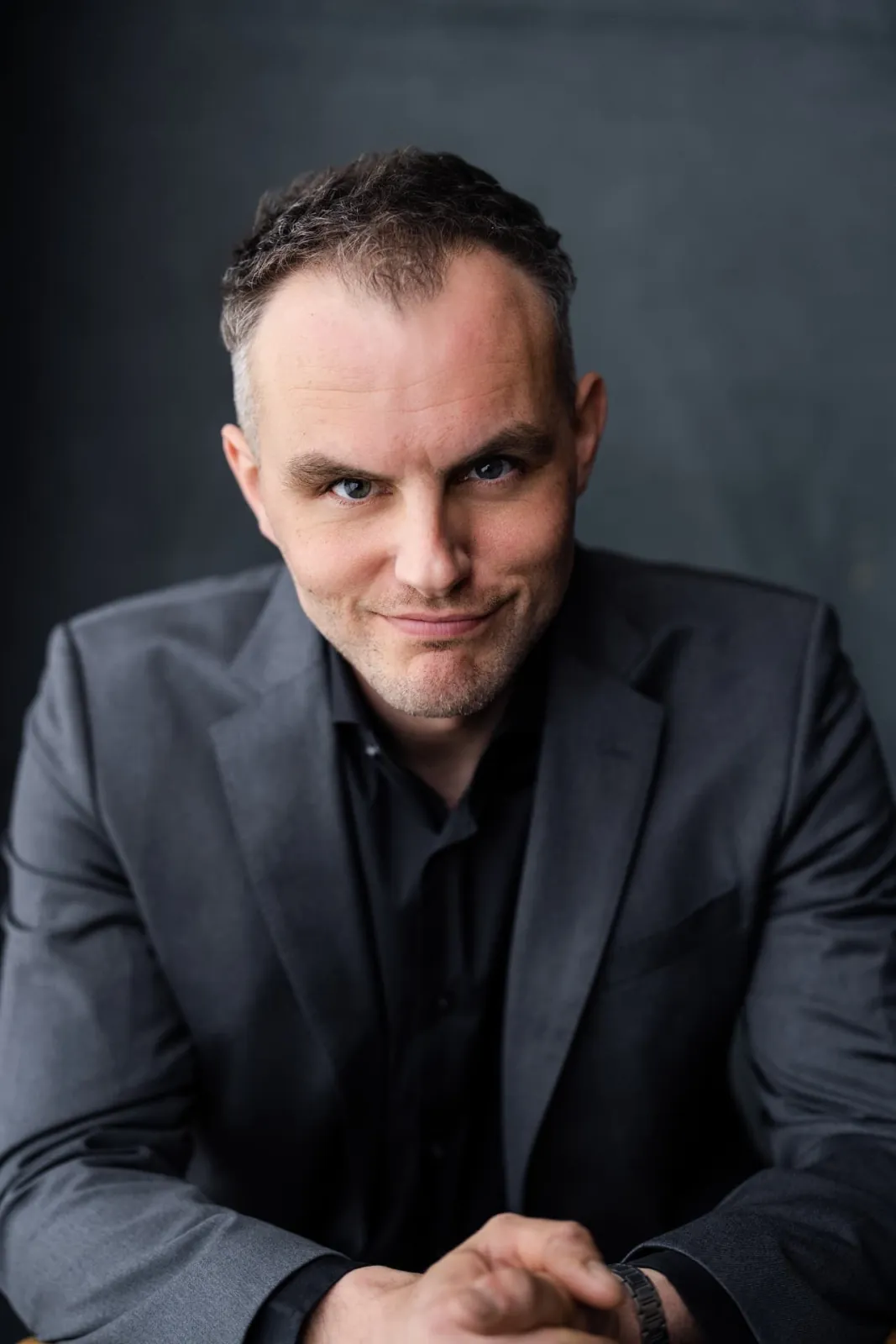Danny Solomon headshot — grey suit, three-quarter