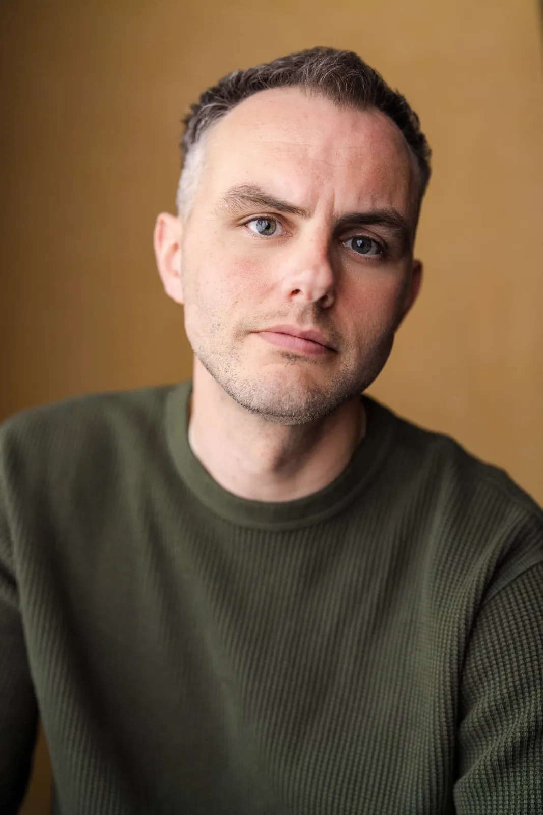 Danny Solomon headshot — olive waffle knit